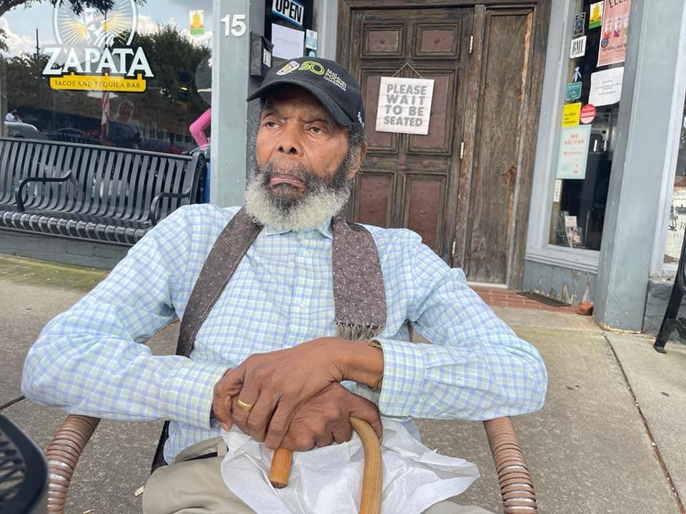 A man sitting on a chair outside a store