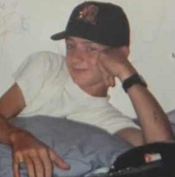 A boy lying in bed with his hand on his face