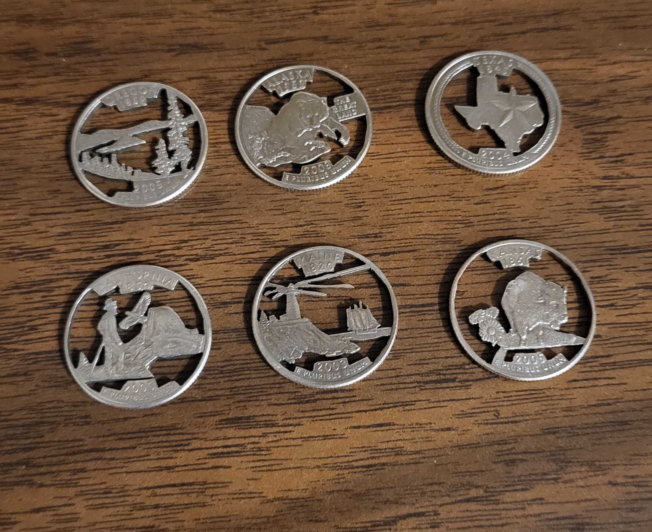 A group of silver coins on a wood surface