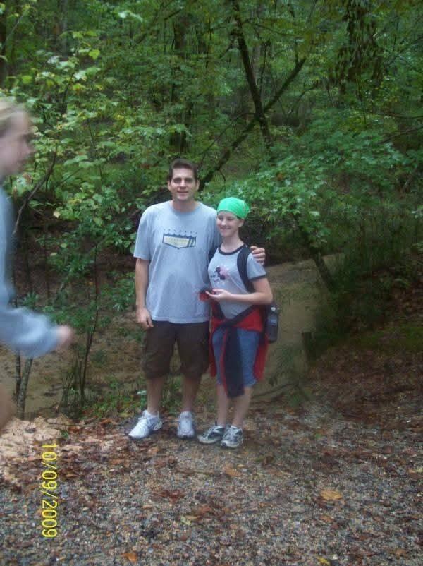 A man and woman standing in a forest