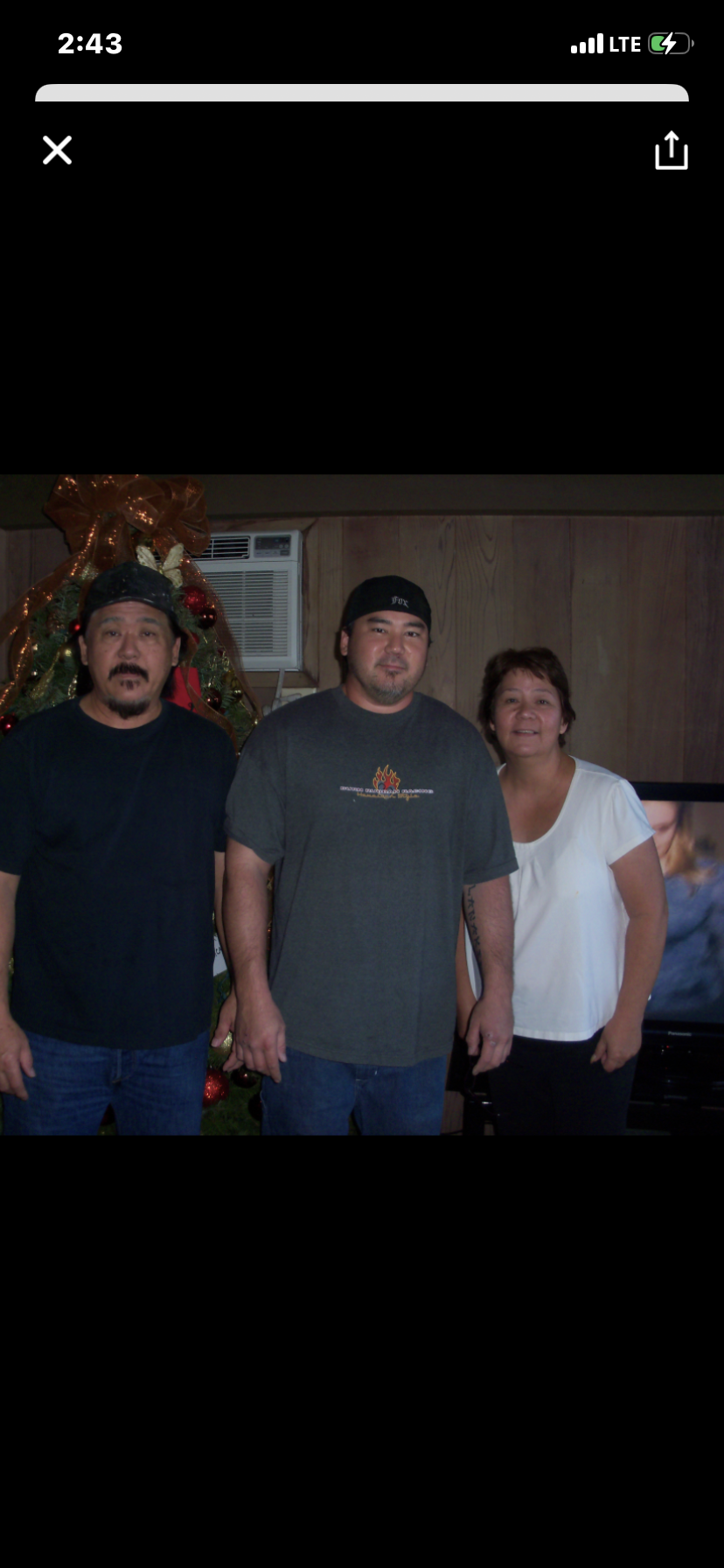 A group of people standing in front of a christmas tree