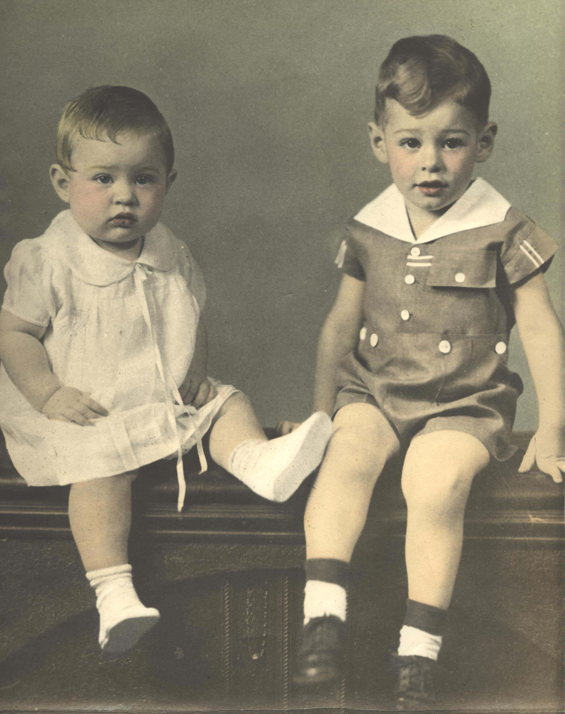 A couple of young children sitting on a table