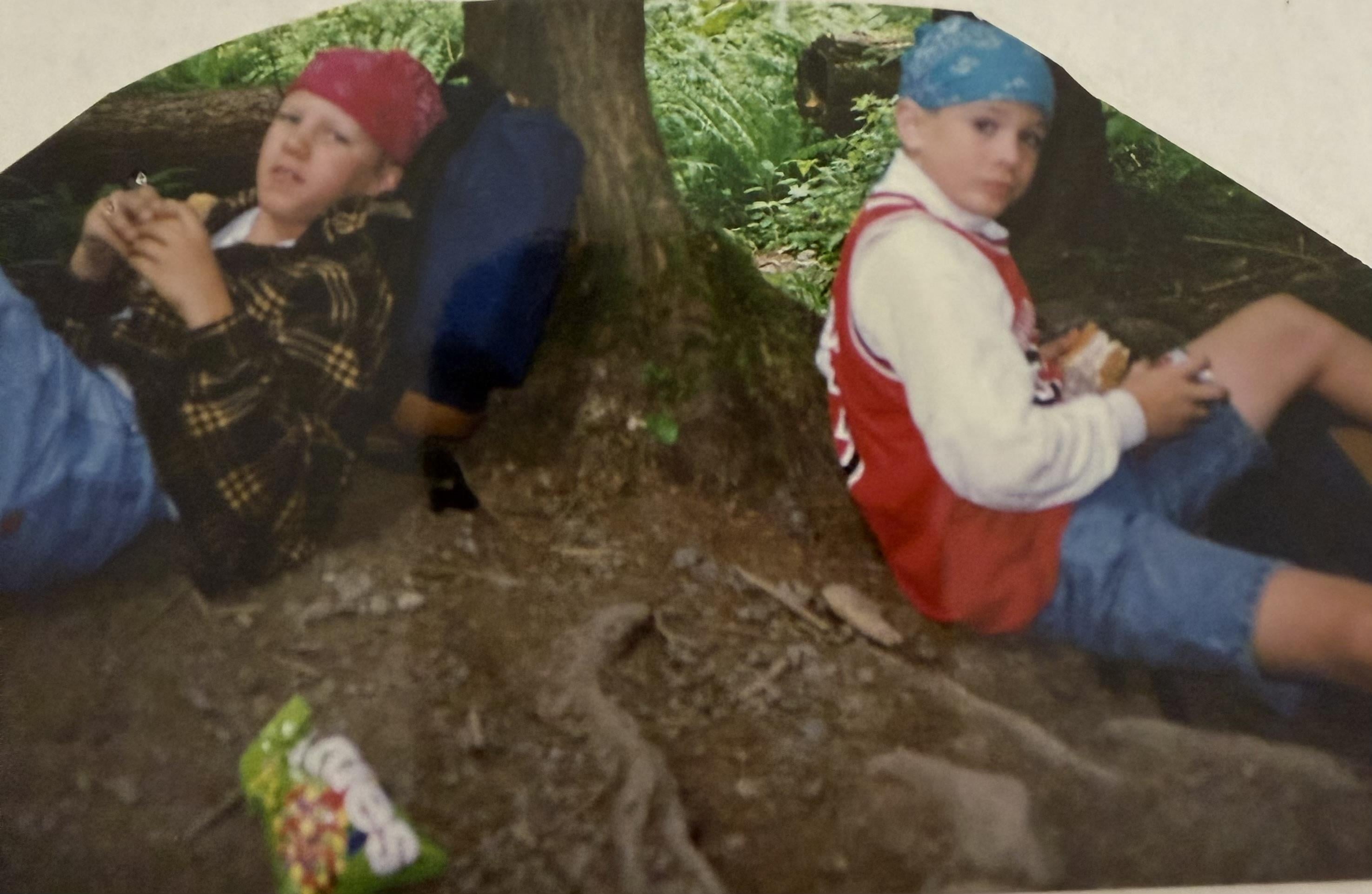 Two boys sitting under a tree