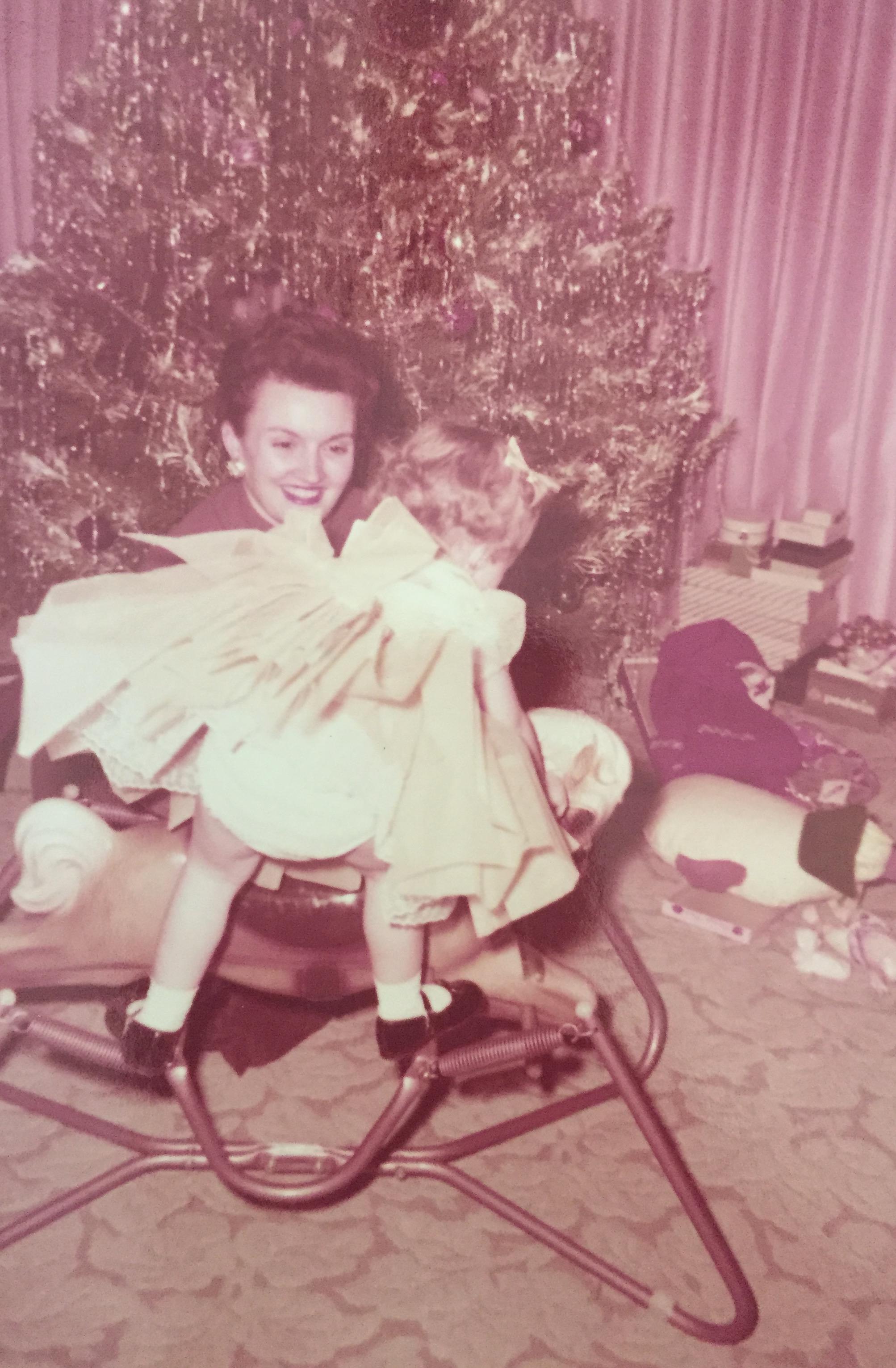 A woman holding a child on a rocking horse