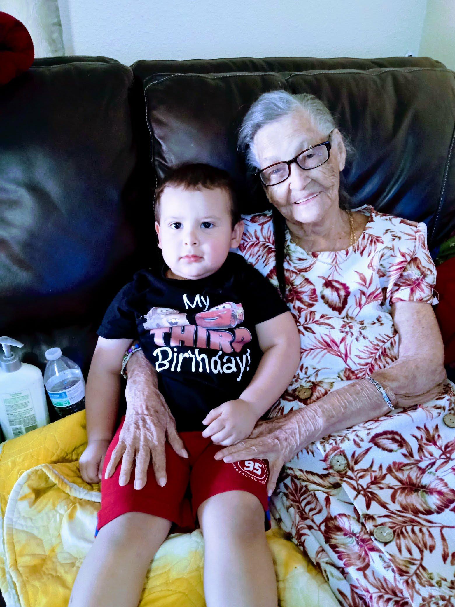 An older woman and a young boy sitting on a couch