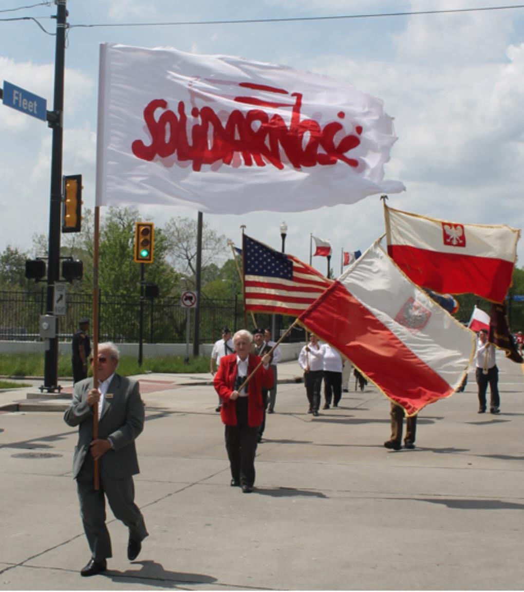 A group of people walking on a street holding flags