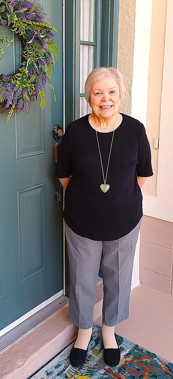 An older woman standing in front of a door