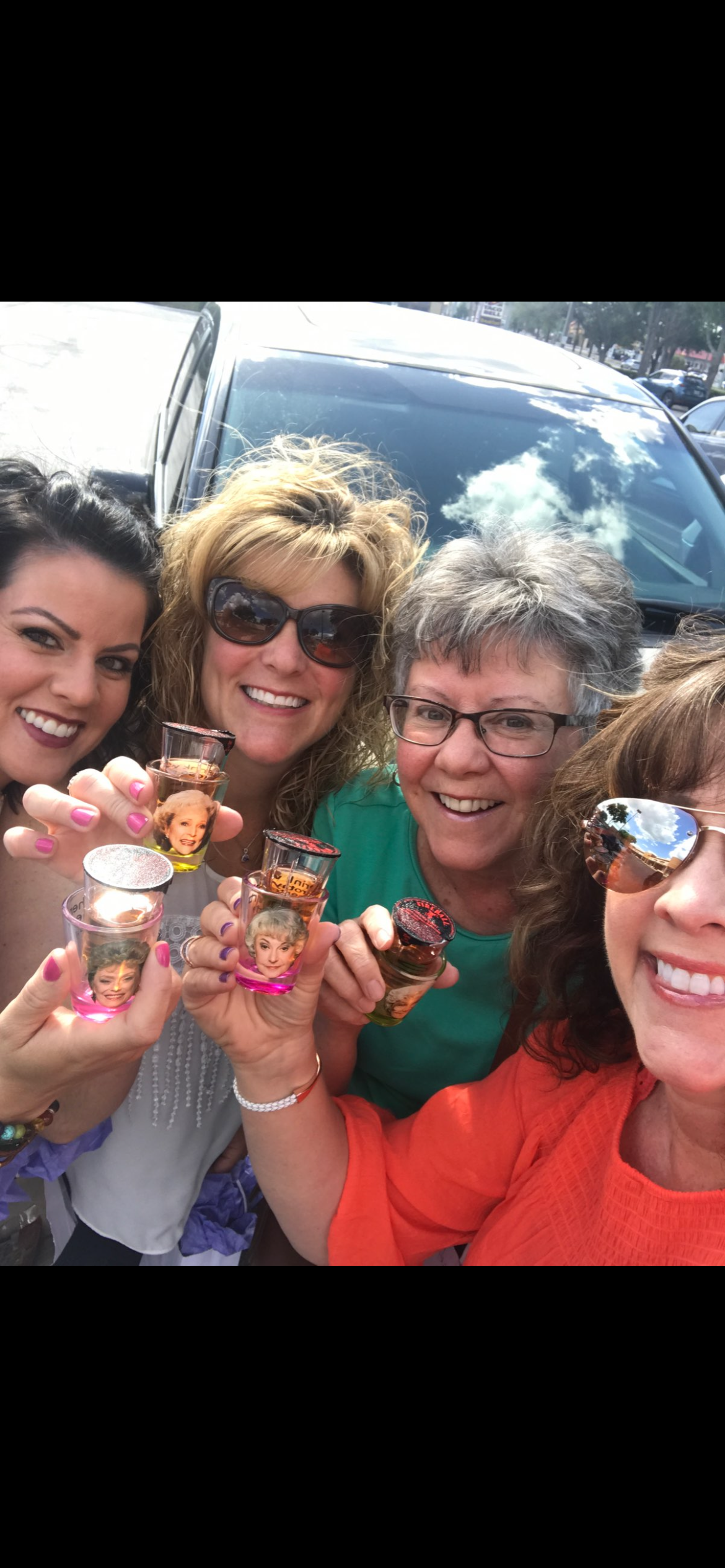 A group of women holding shot glasses