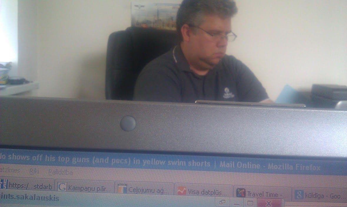 A man sitting in a chair looking at a computer screen