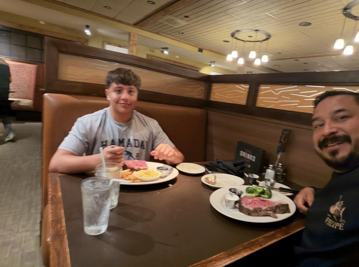 Two men sitting at a table with plates of food