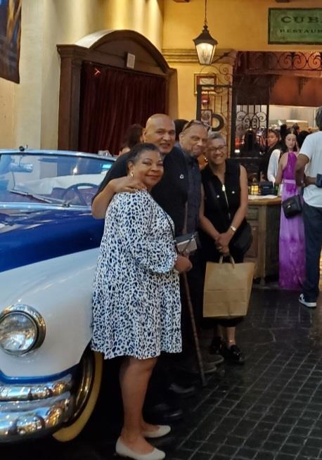 A group of people standing next to a car