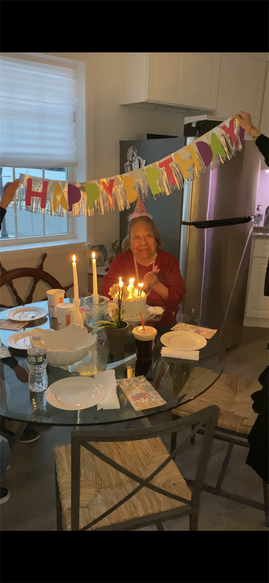 A woman sitting at a table with a birthday cake