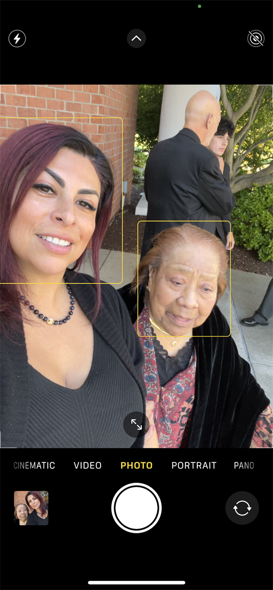 A woman taking a selfie with a man and woman