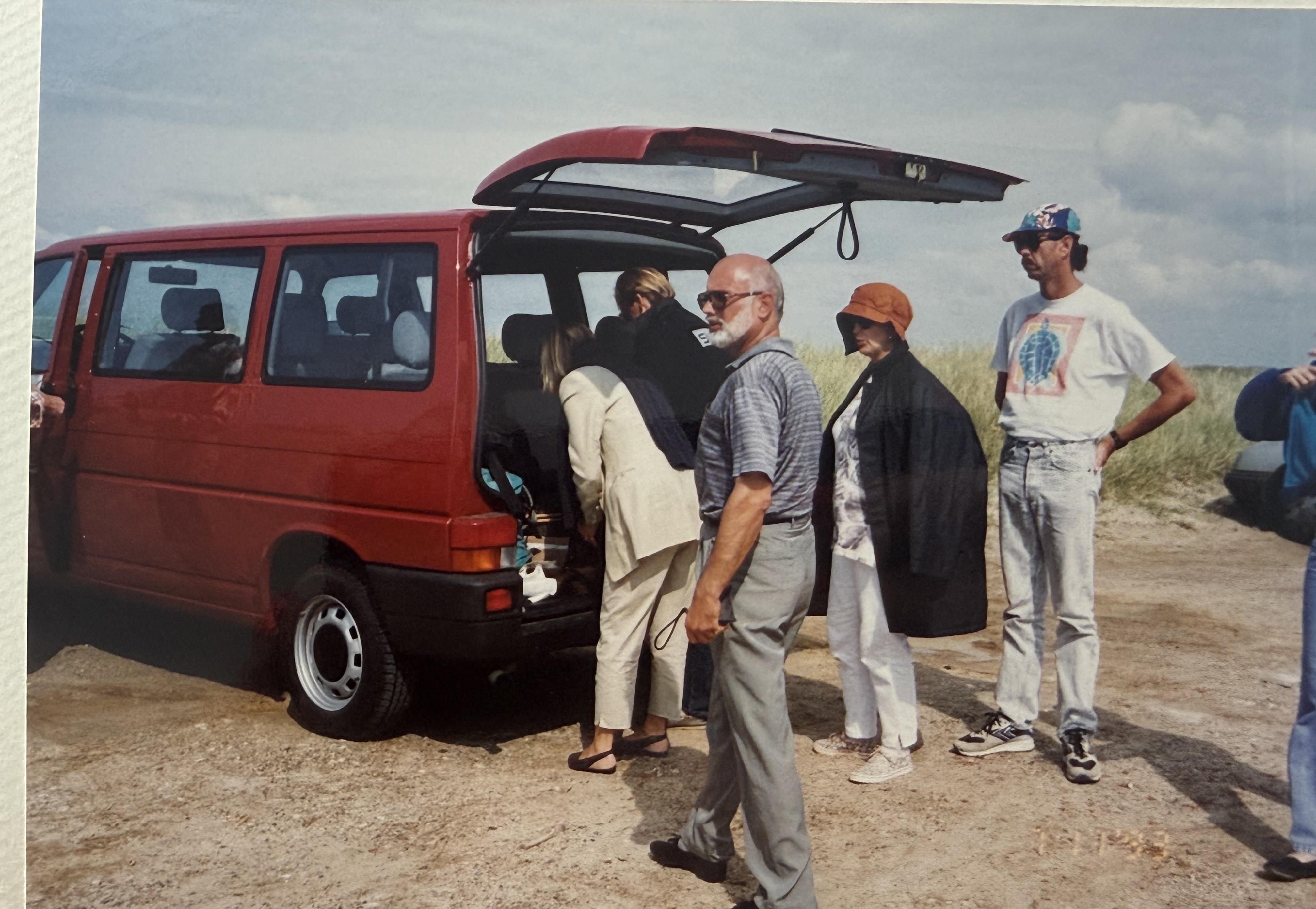 A group of people standing next to a van