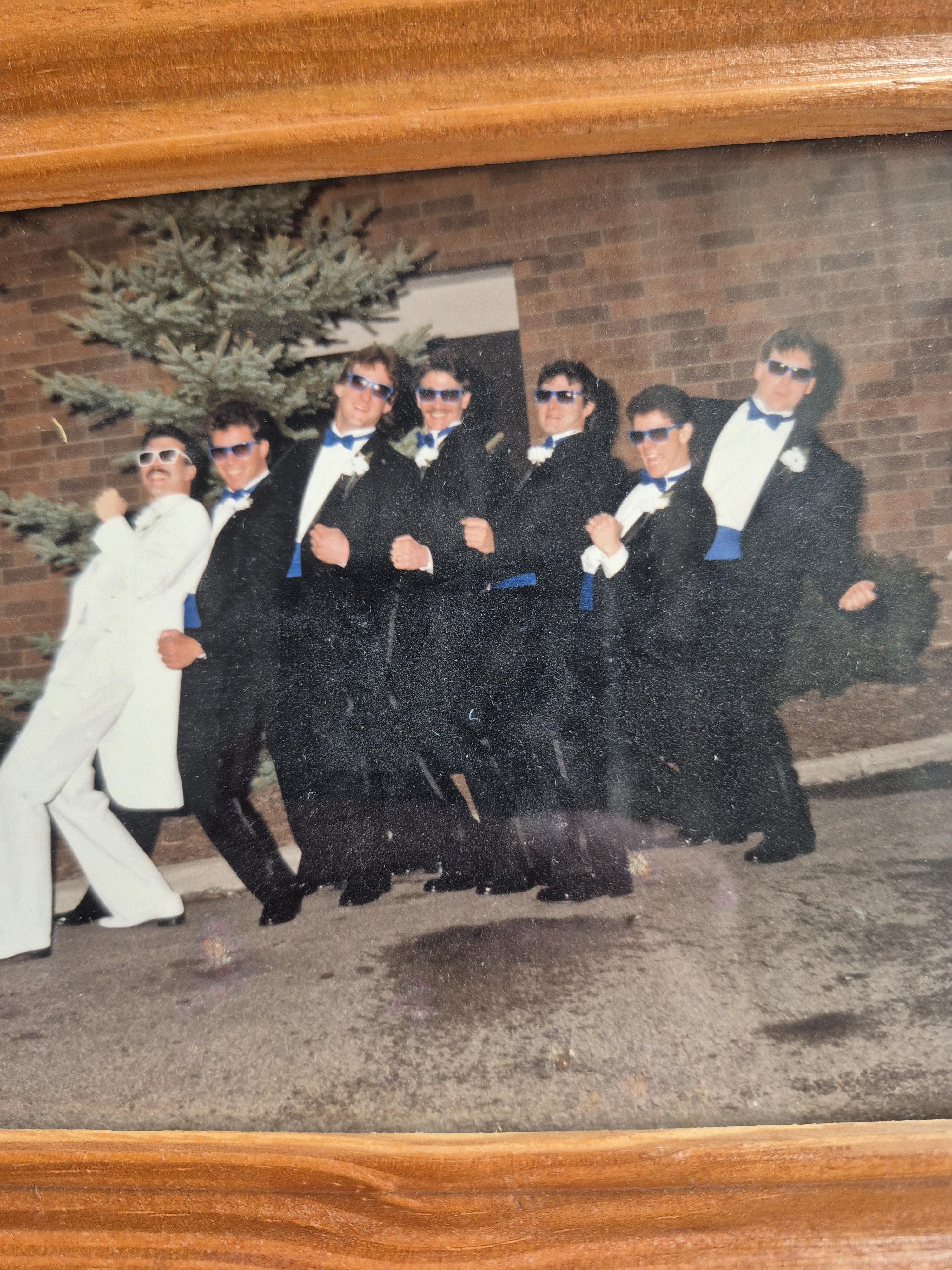 A group of men in suits and sunglasses posing for a photo