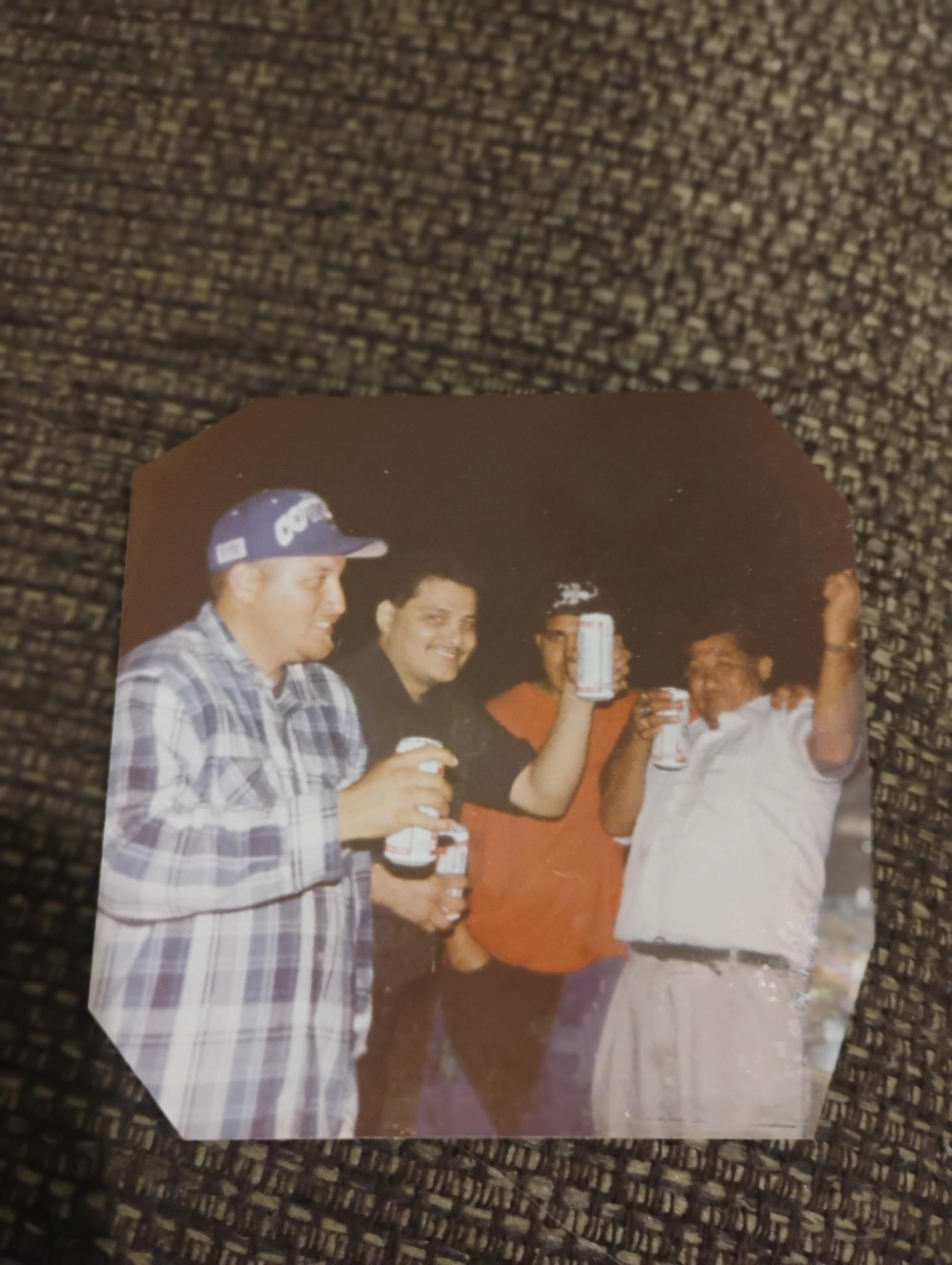 A group of men holding beer cans