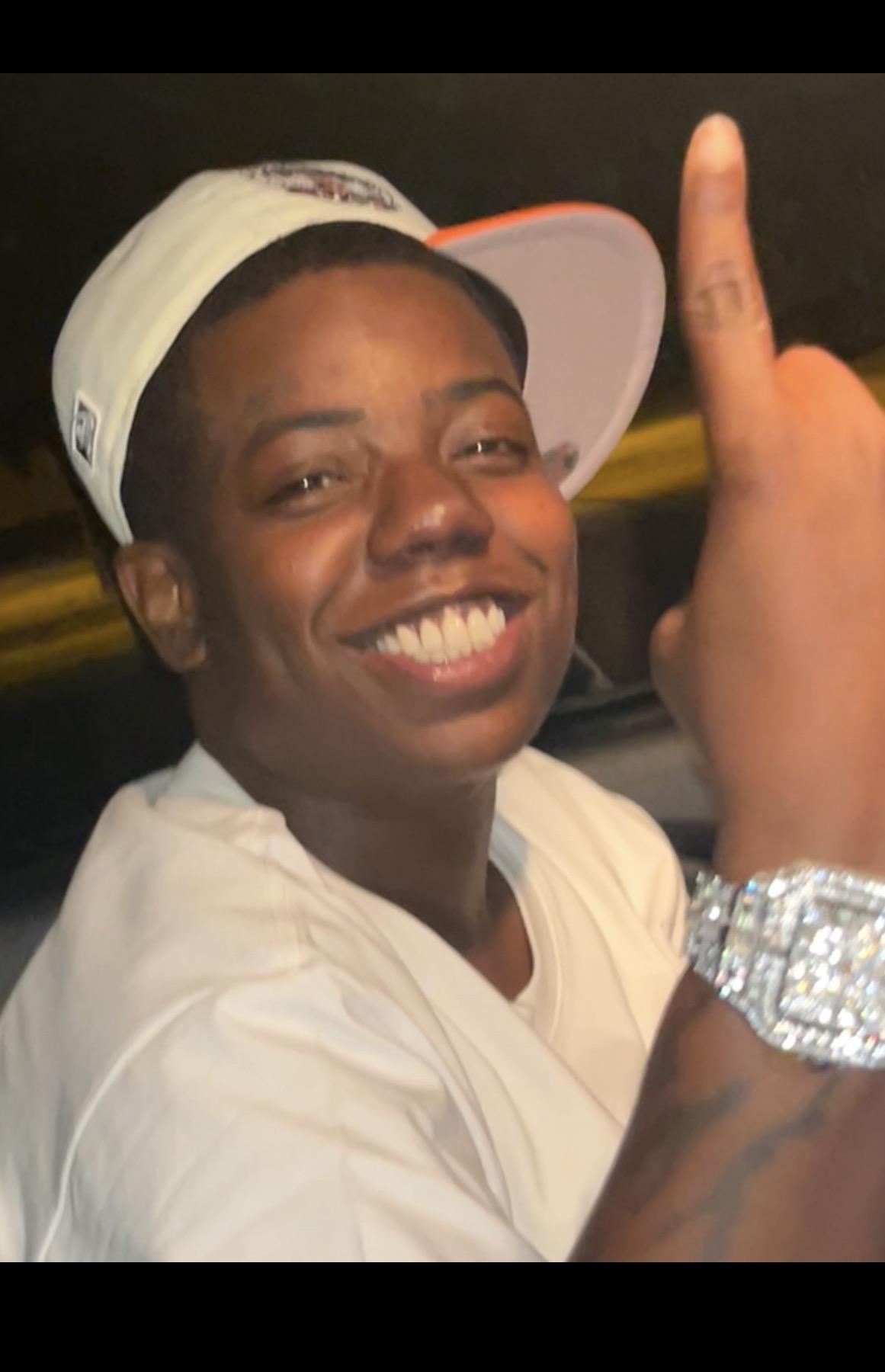 A man wearing a hat and holding up his finger