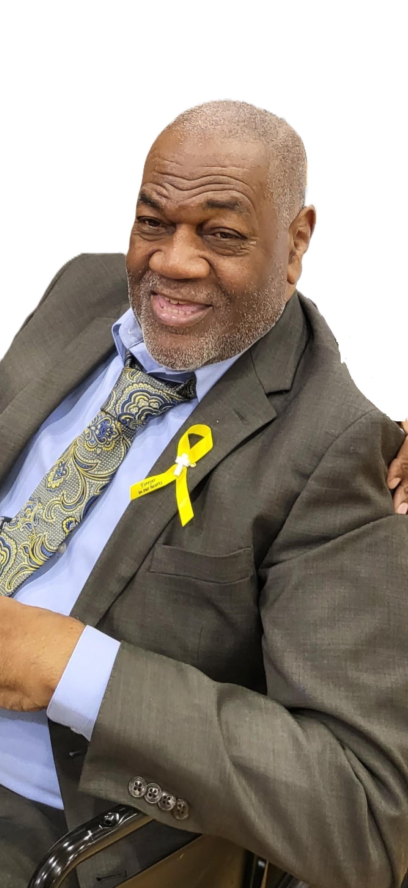 A man in a suit with a yellow ribbon