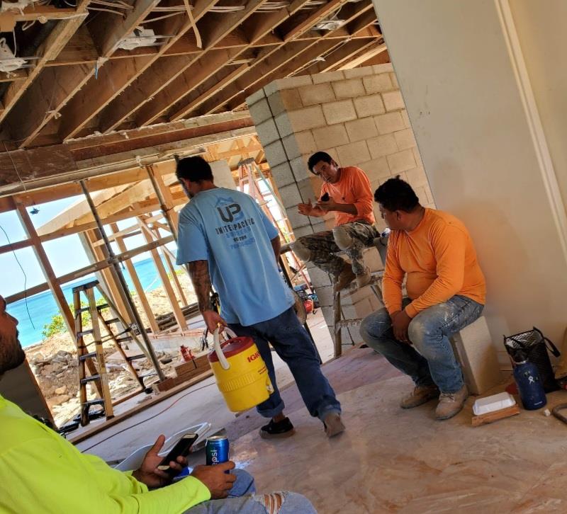 A group of men in a room with a yellow bucket