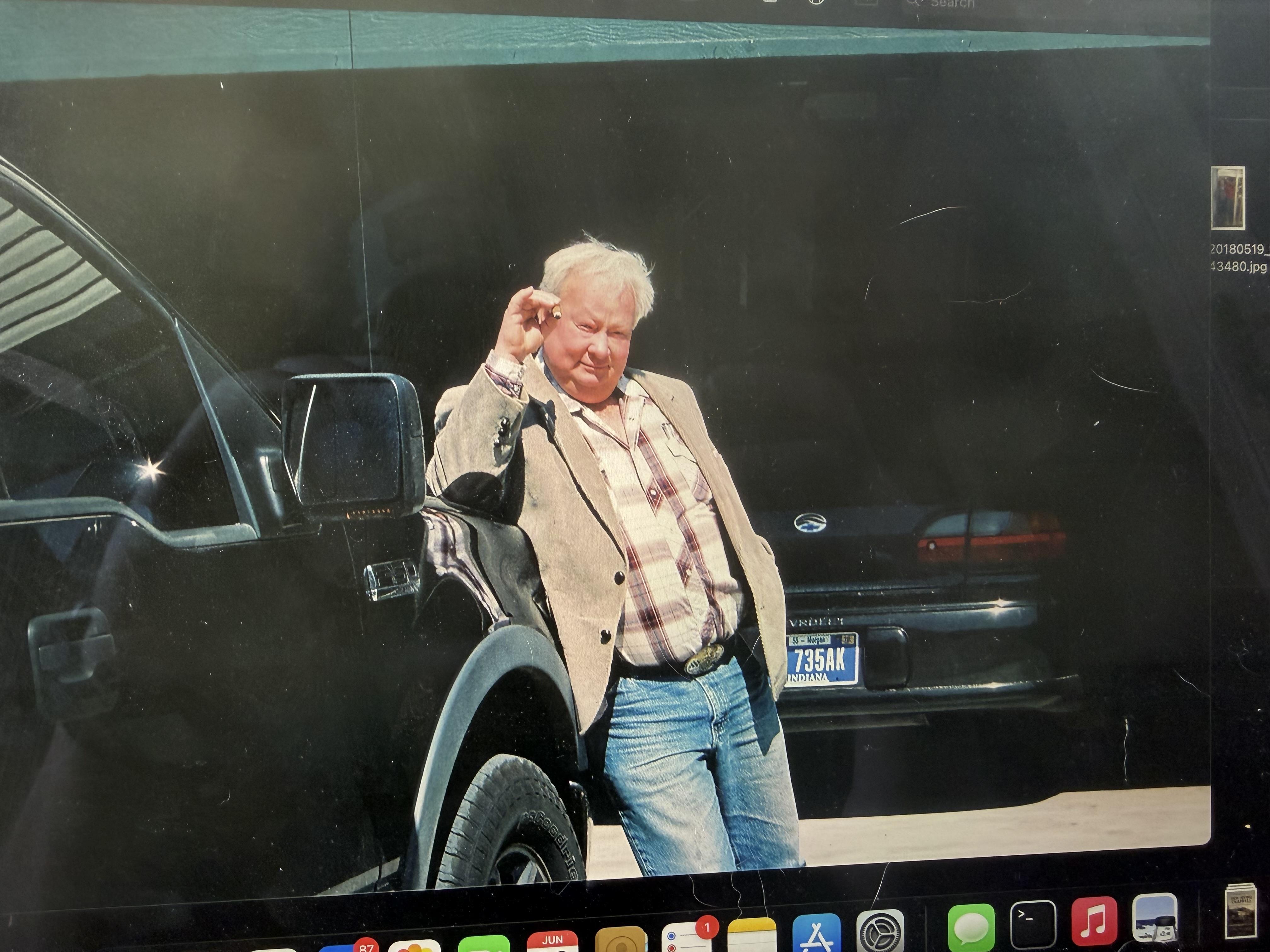A man leaning against a car