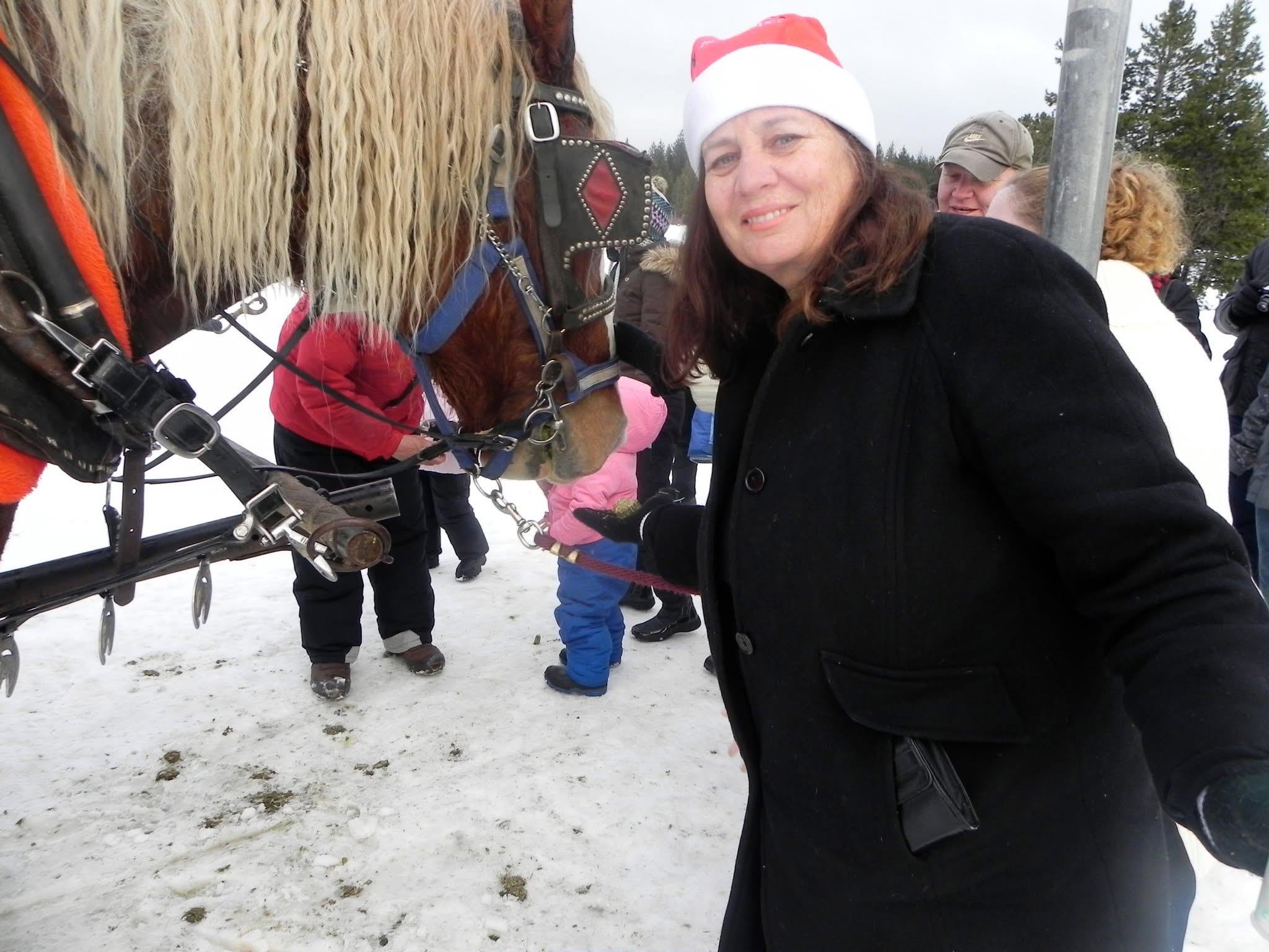 A woman standing next to a horse