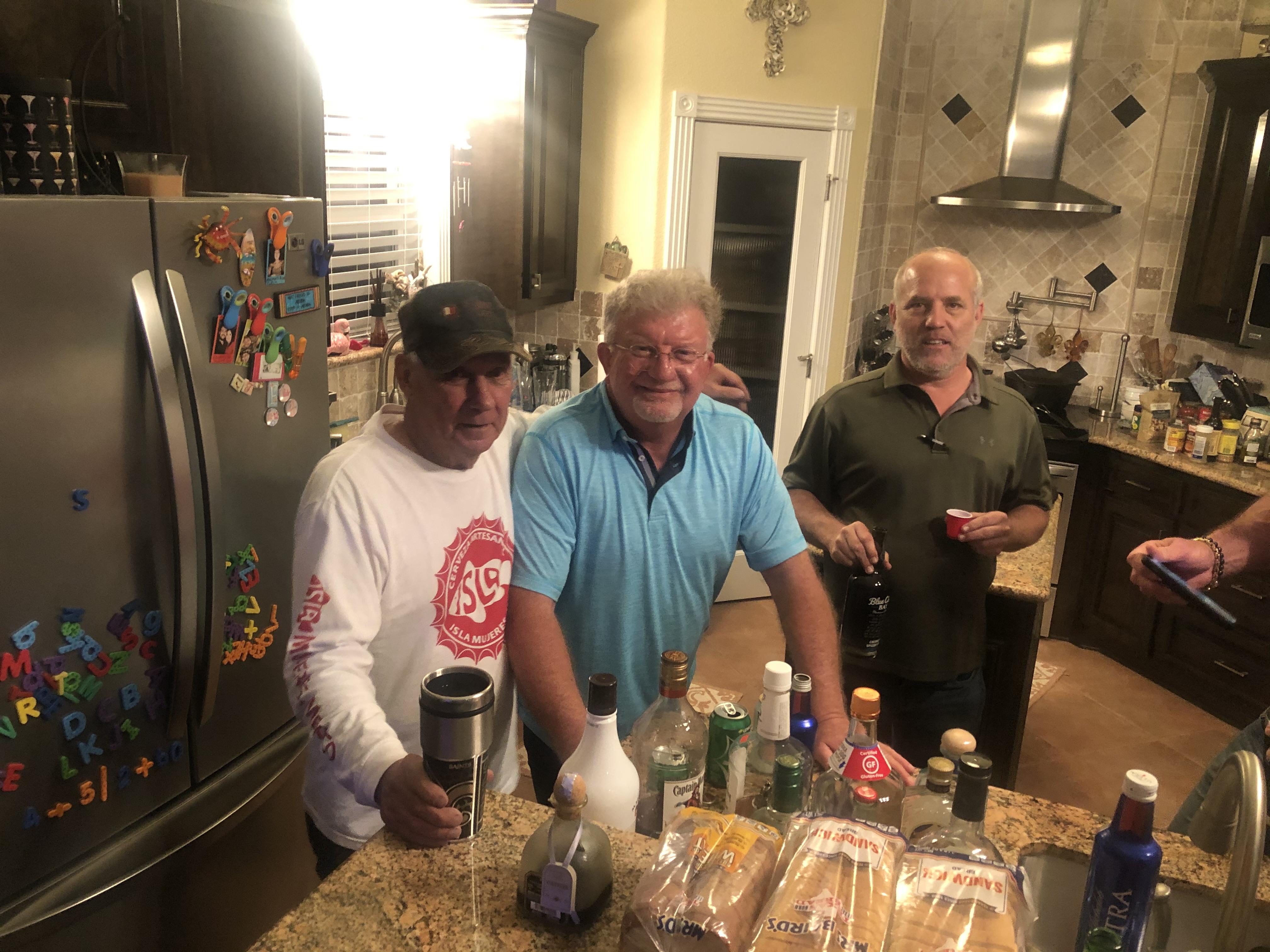 A group of men standing in a kitchen