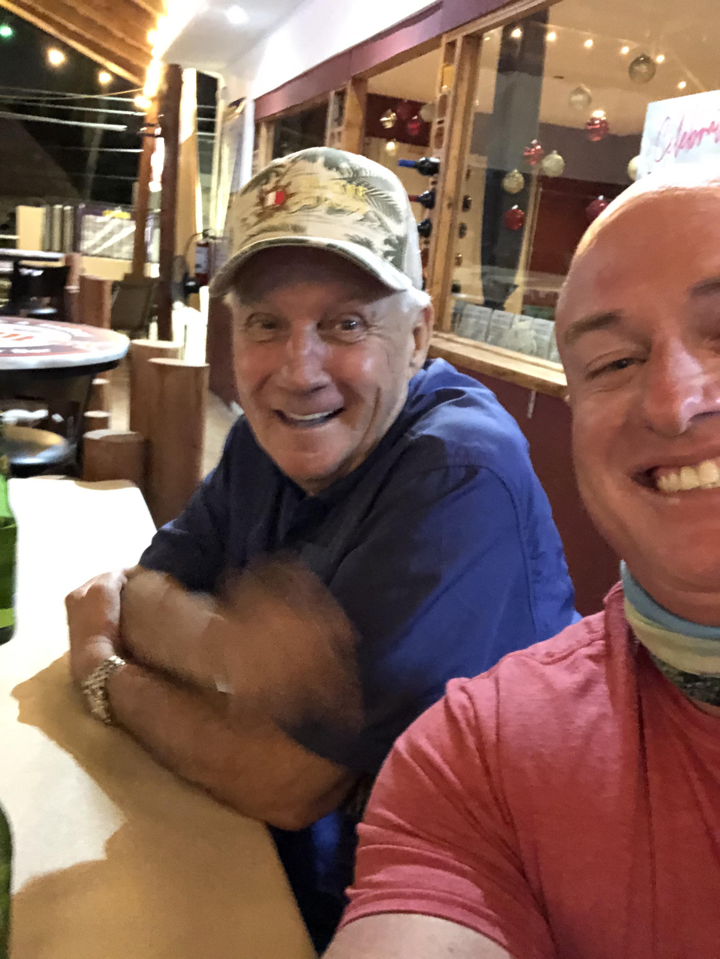 Two men sitting at a table smiling