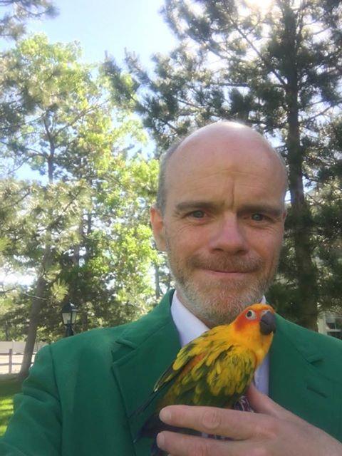 A man in a suit holding a bird