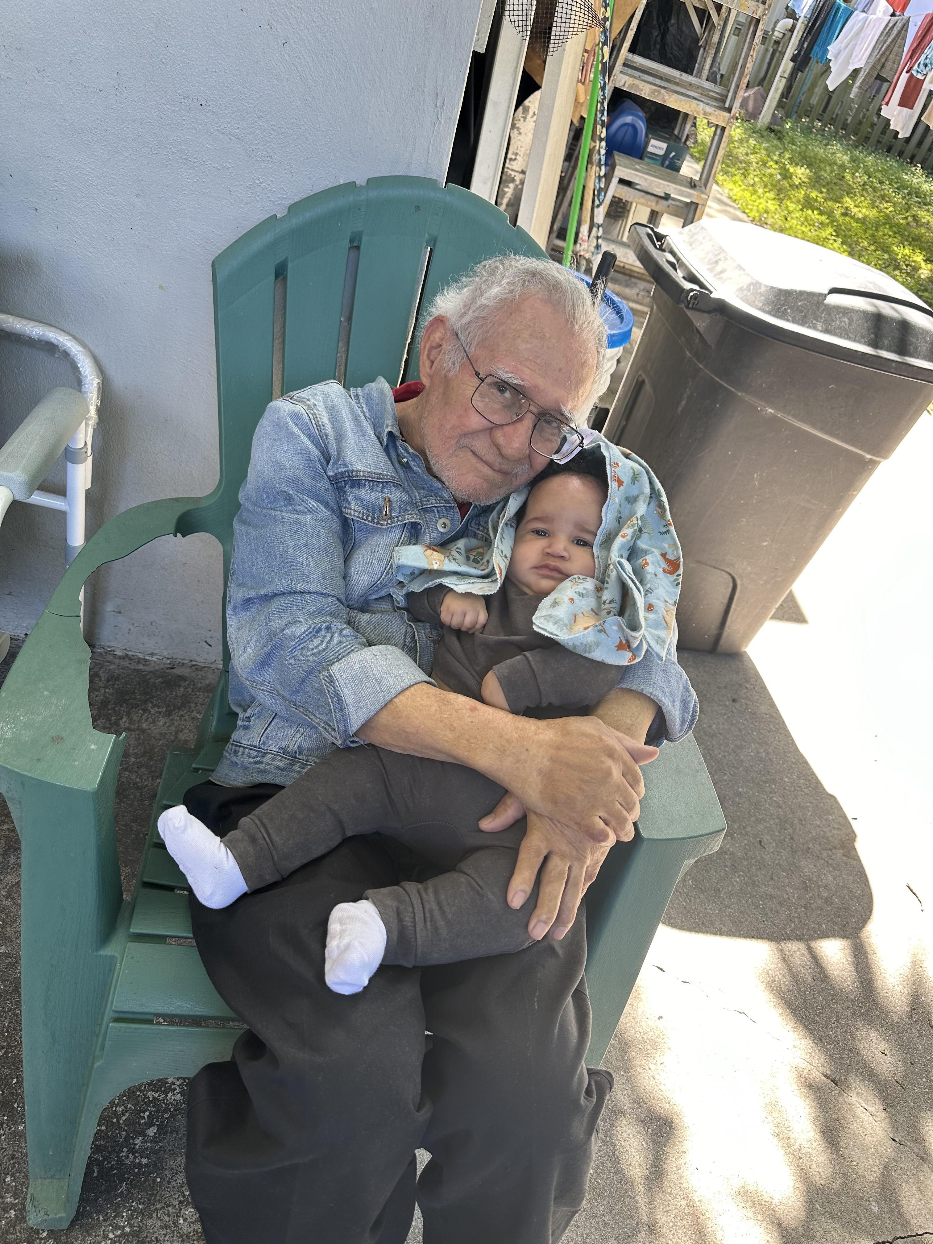 An old man holding a baby