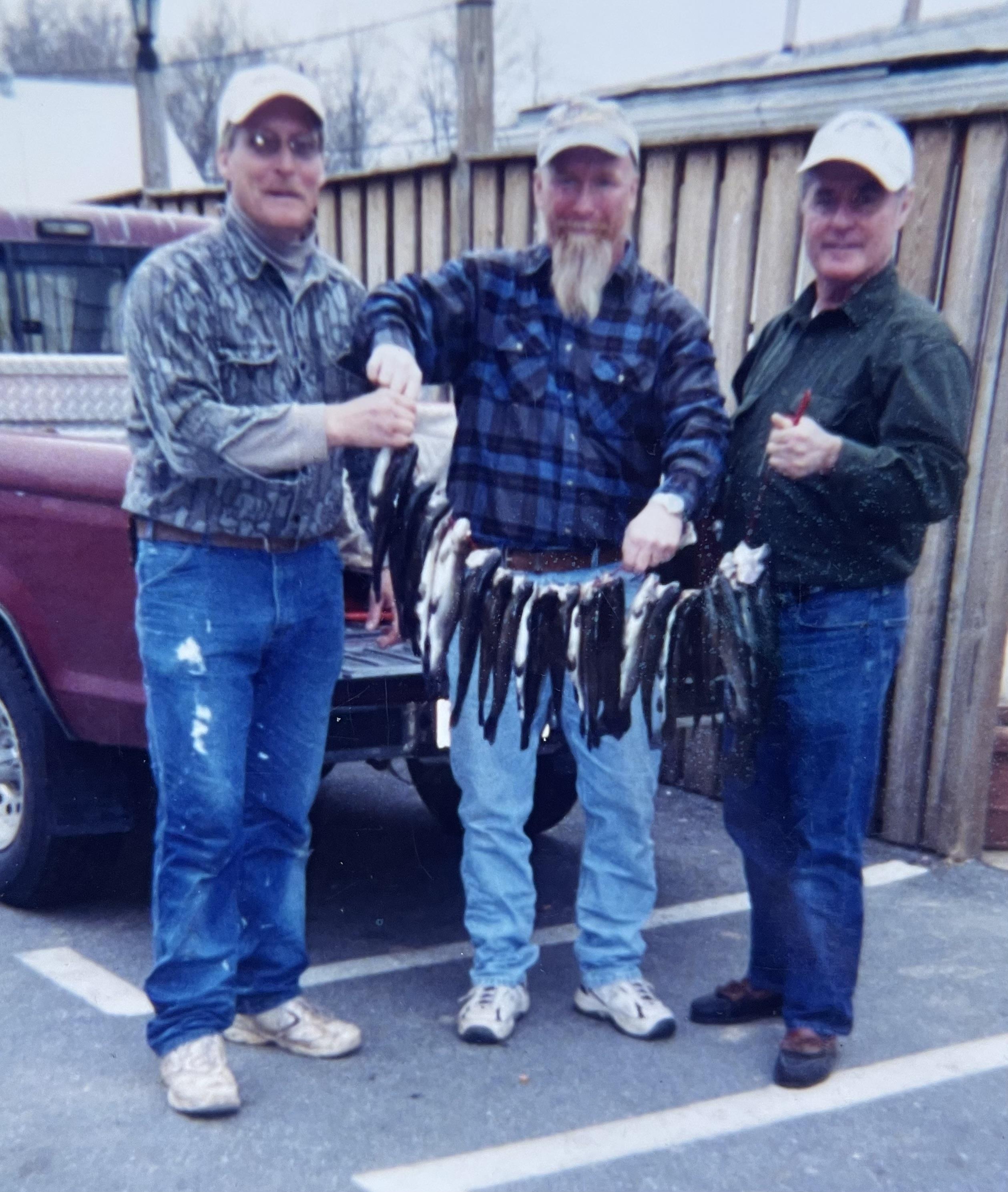 A group of men holding fish