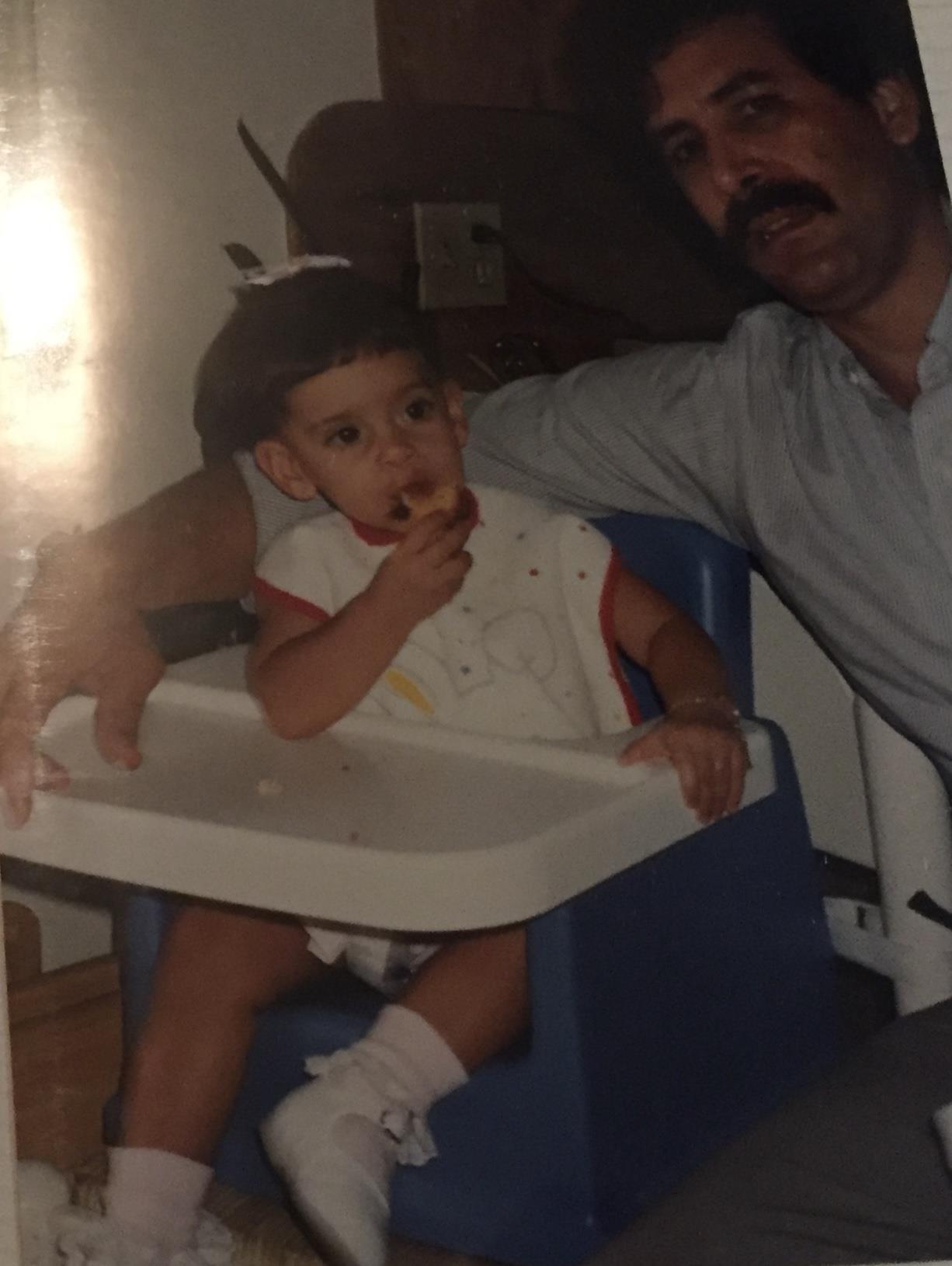 A man sitting in a high chair with a baby