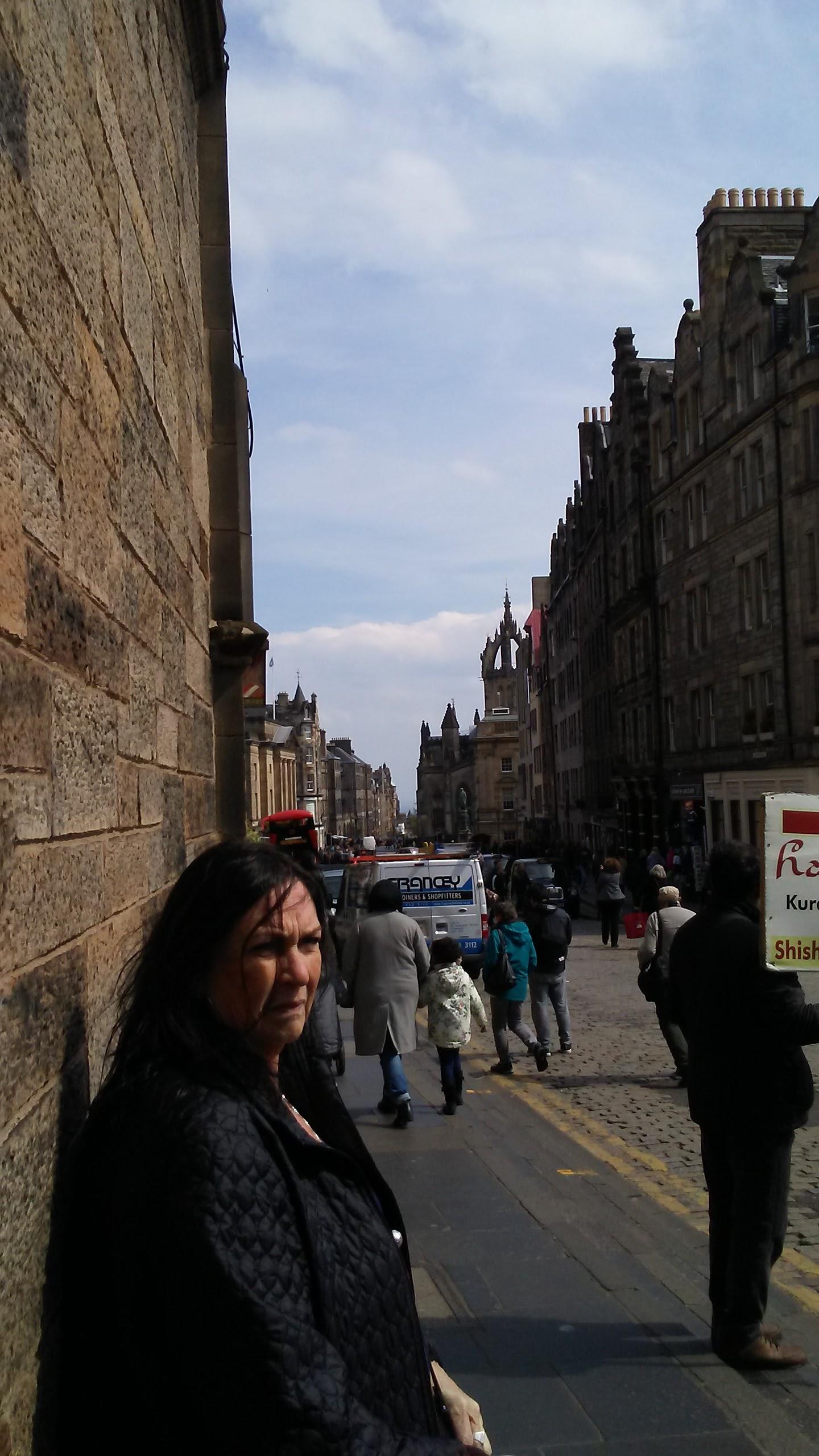 A woman leaning against a wall in a city