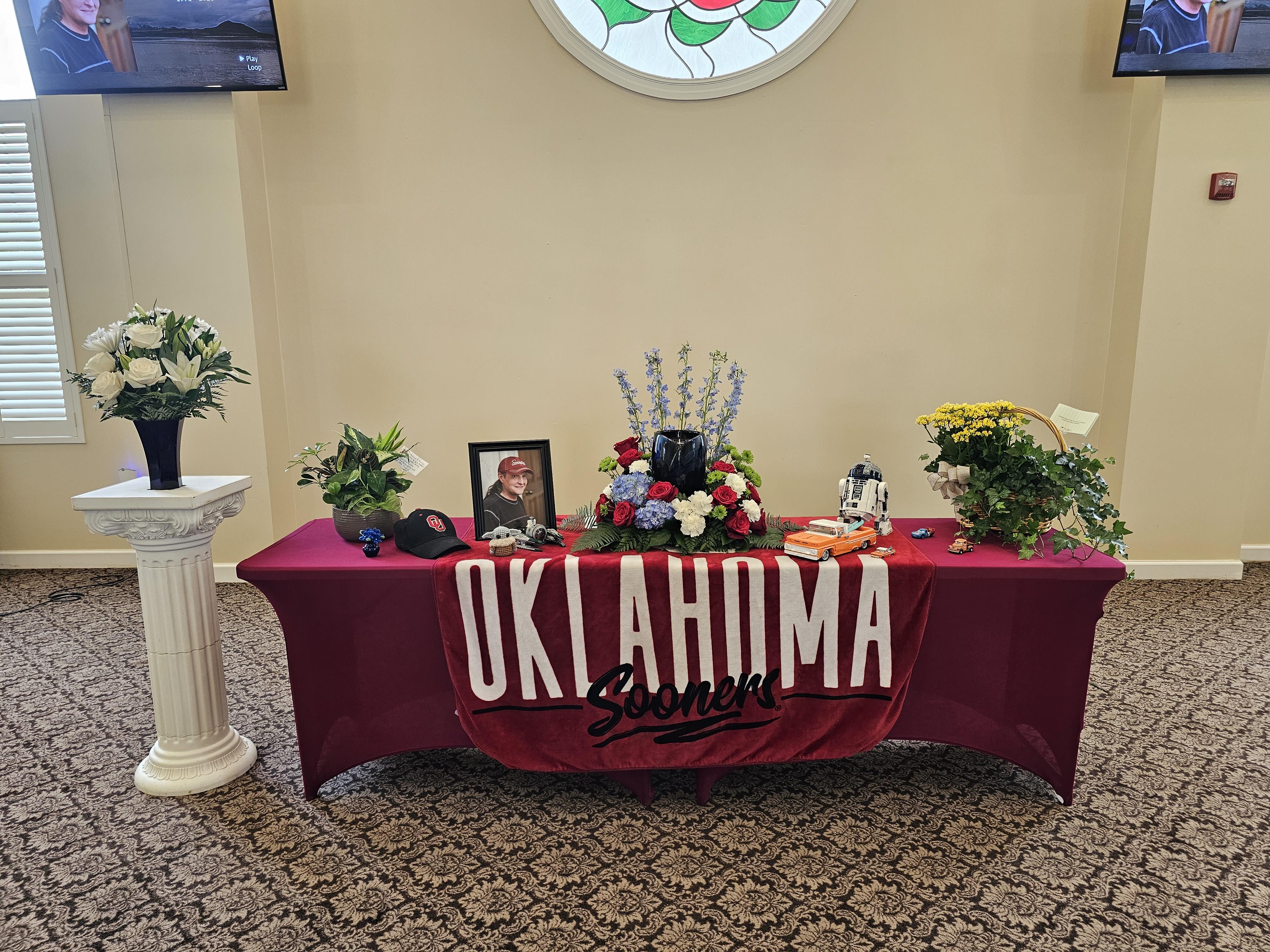 A table with a red tablecloth with a picture of a man and a picture of a woman