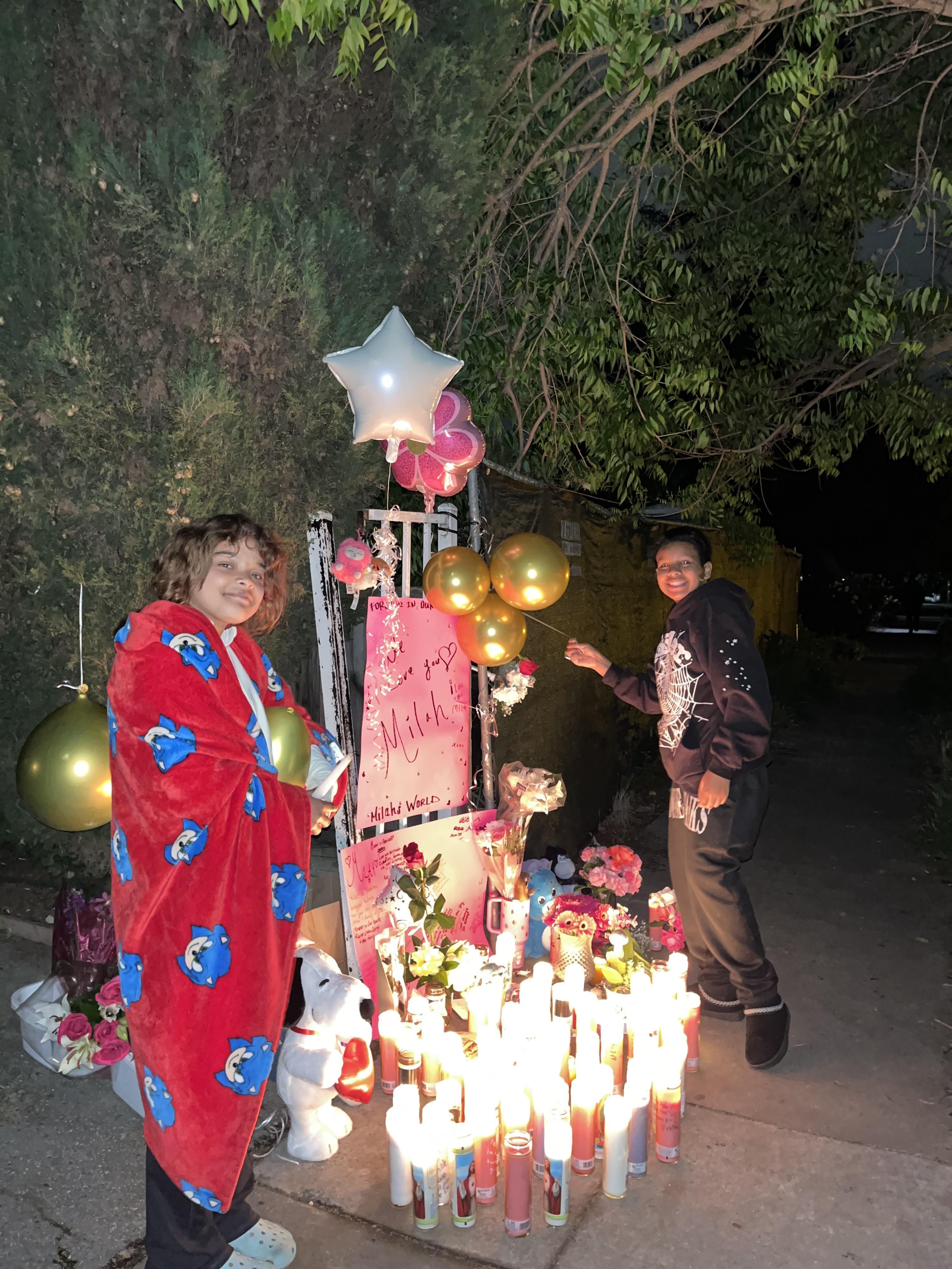 A couple of people standing next to a sign and candles