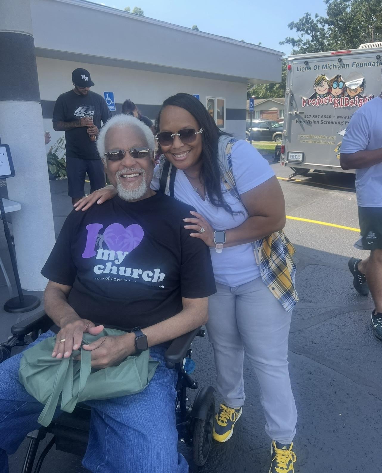 A woman hugging a man in a wheelchair