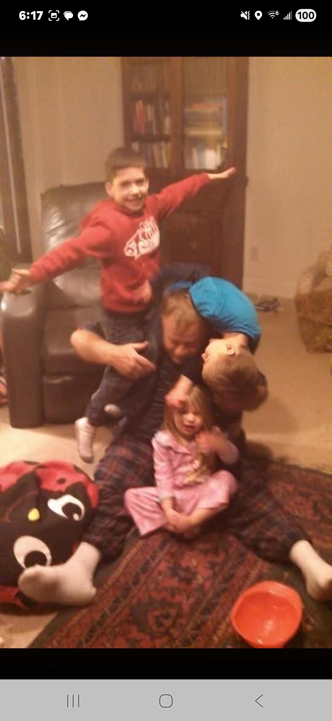 A group of children sitting on a man's lap