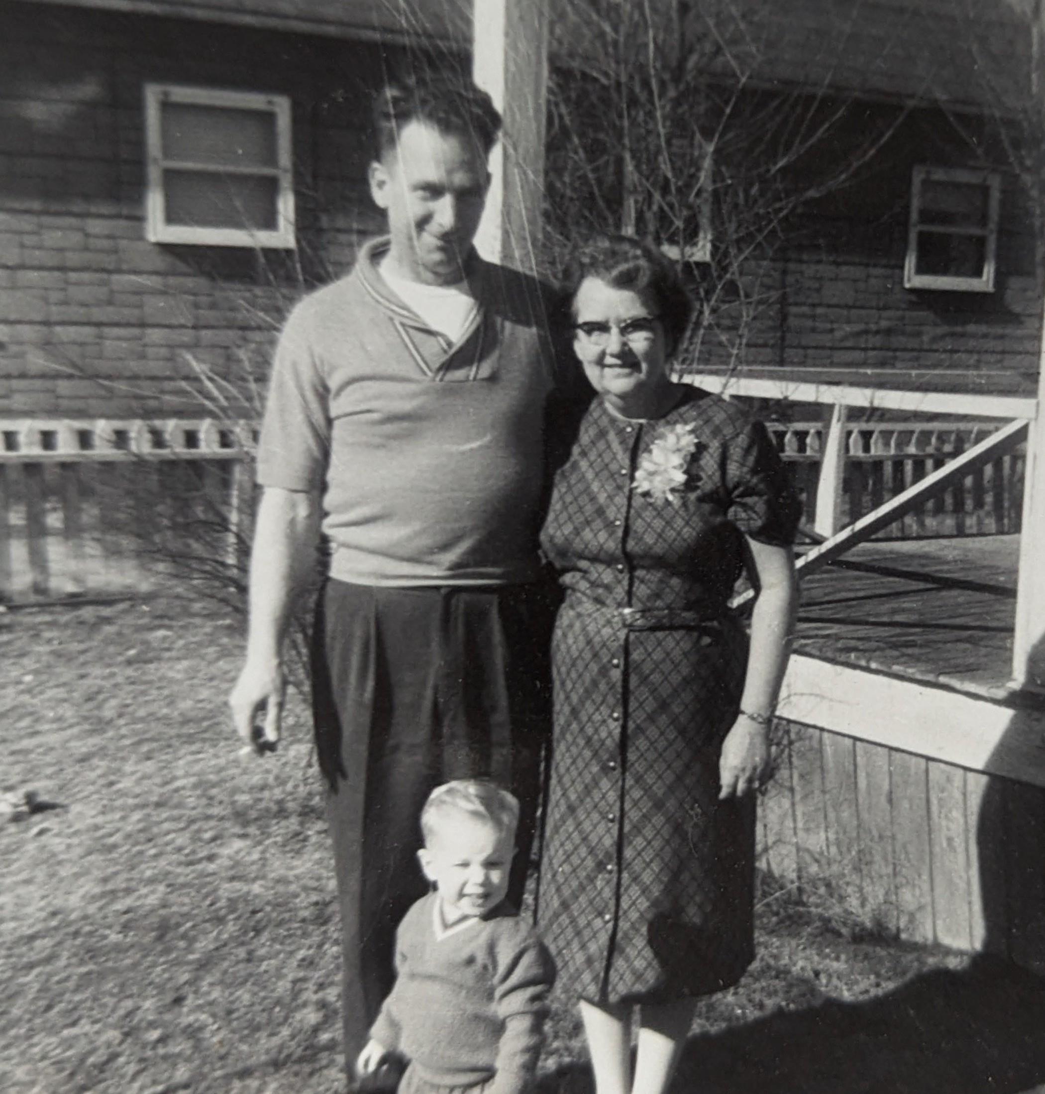 A man and woman standing in front of a house
