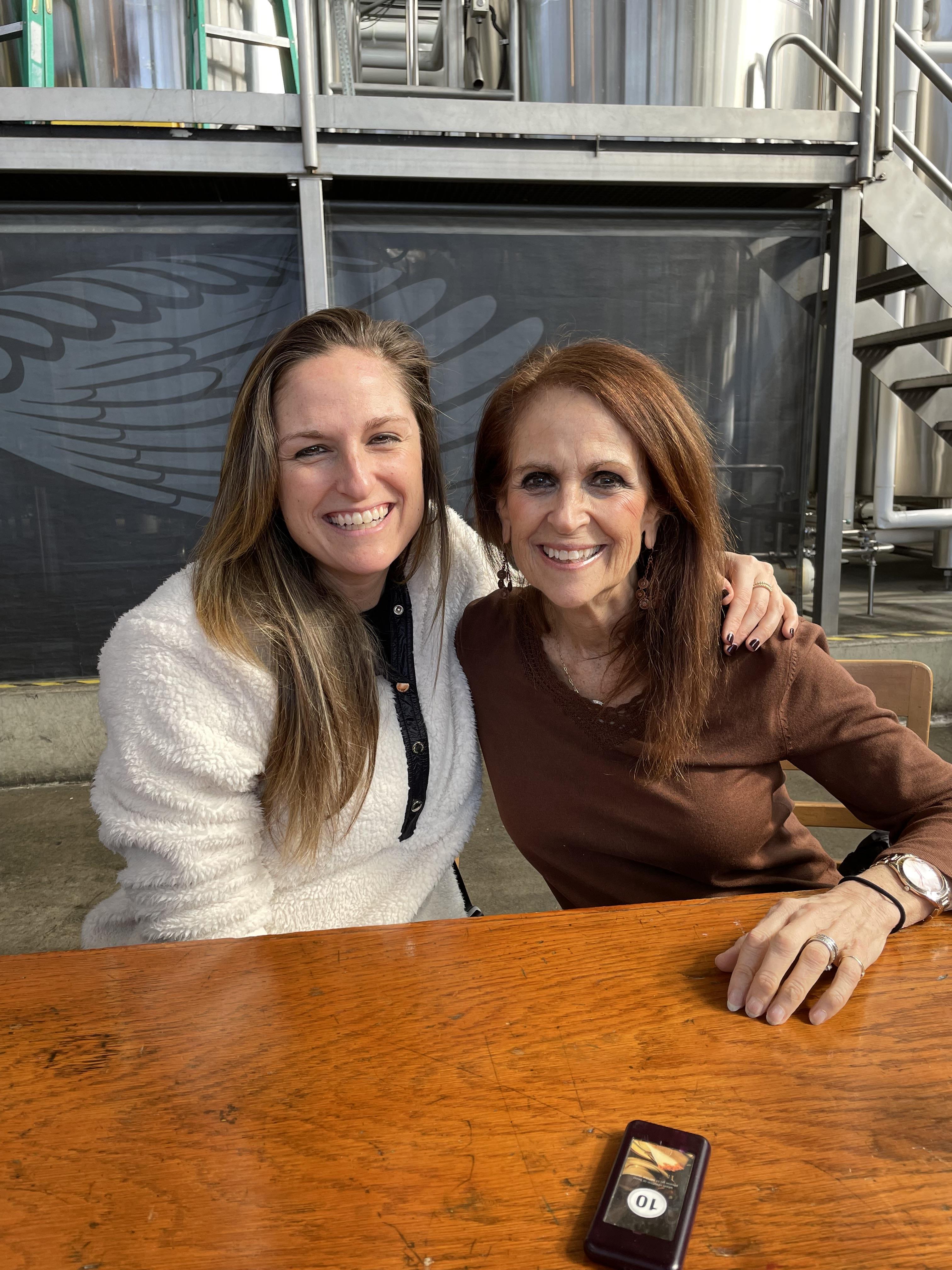 Two women sitting at a table smiling