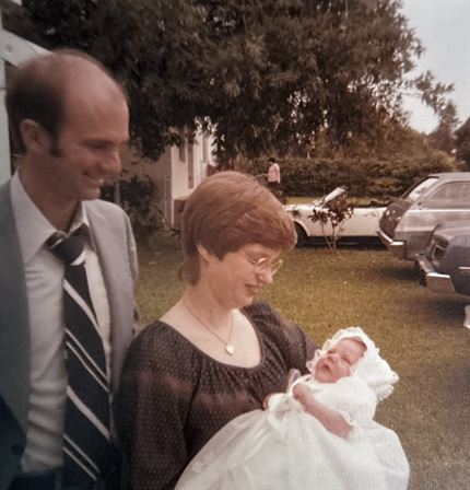 A man and woman holding a baby