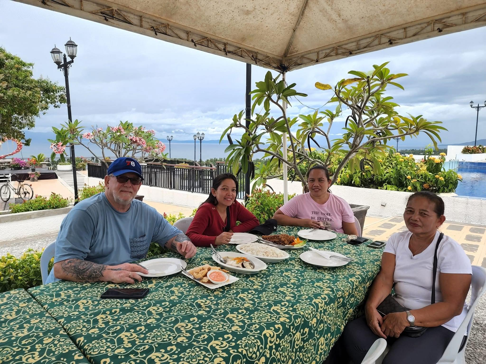 A group of people sitting at a table with plates of food