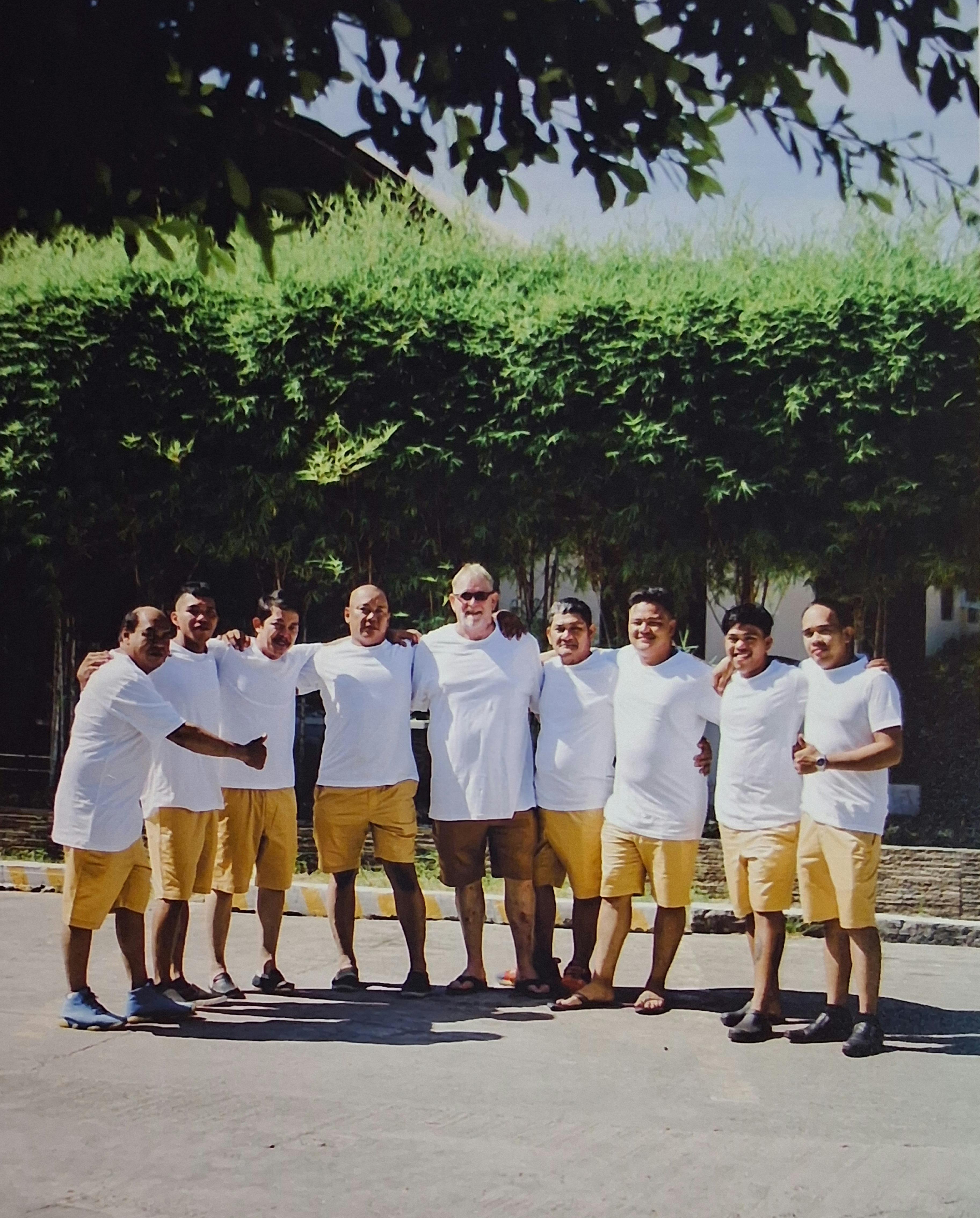 A group of men in white shirts and yellow shorts