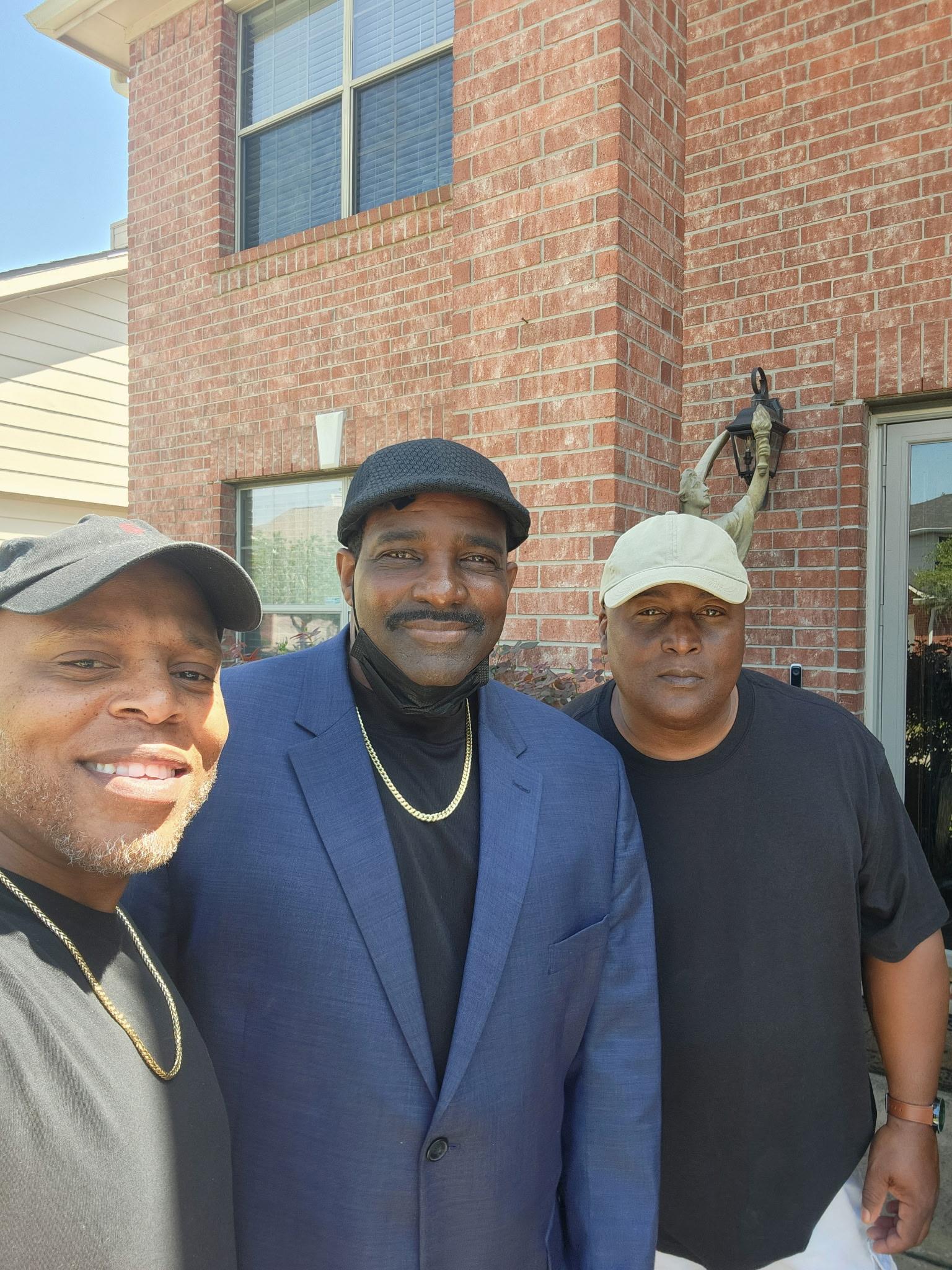 A group of men standing in front of a brick building
