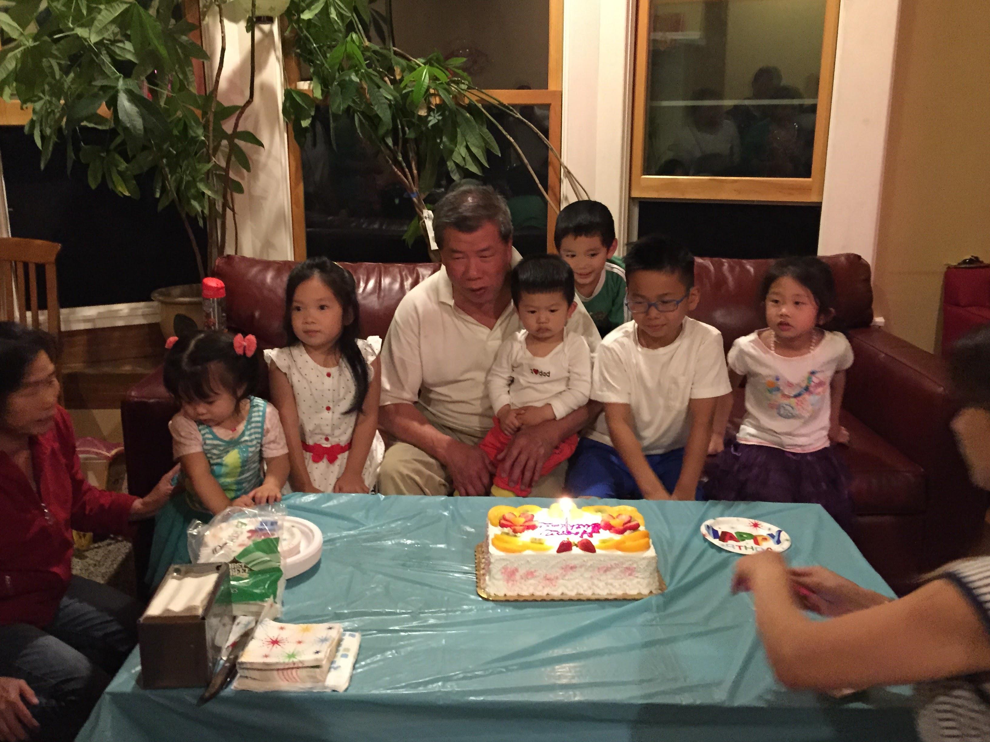 A group of kids sitting around a table with a birthday cake