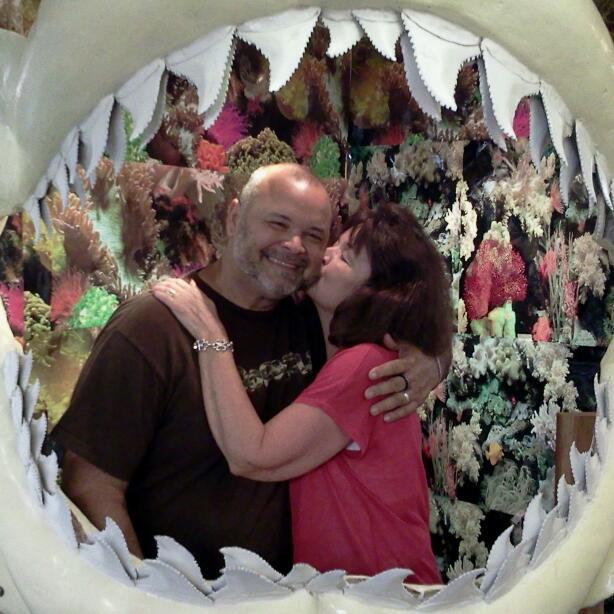 A man and woman hugging in a shark's mouth