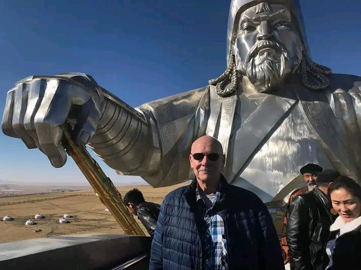 A man standing in front of a large statue