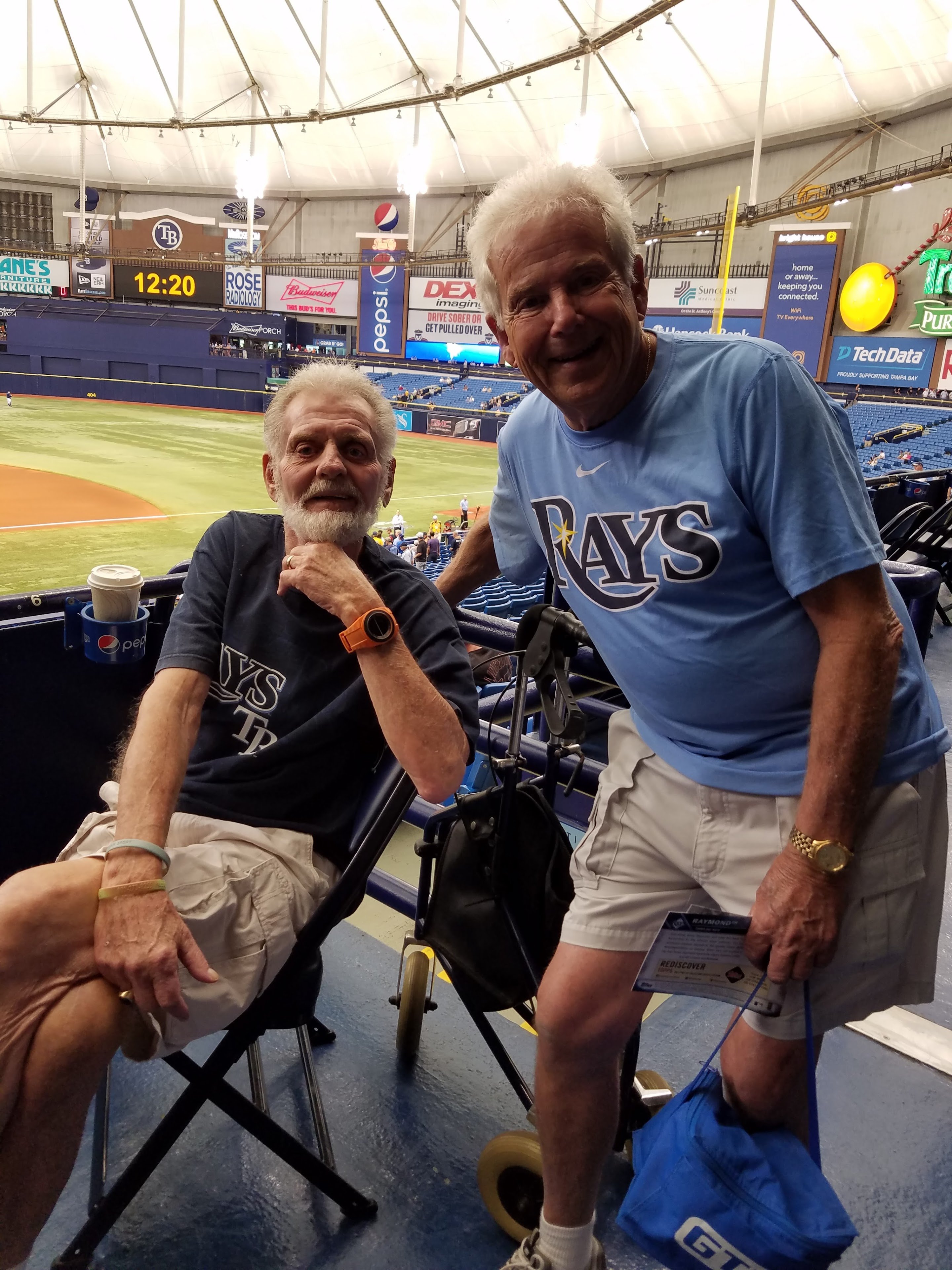 Two men sitting in chairs in a stadium