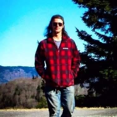 A man wearing sunglasses and a red flannel shirt