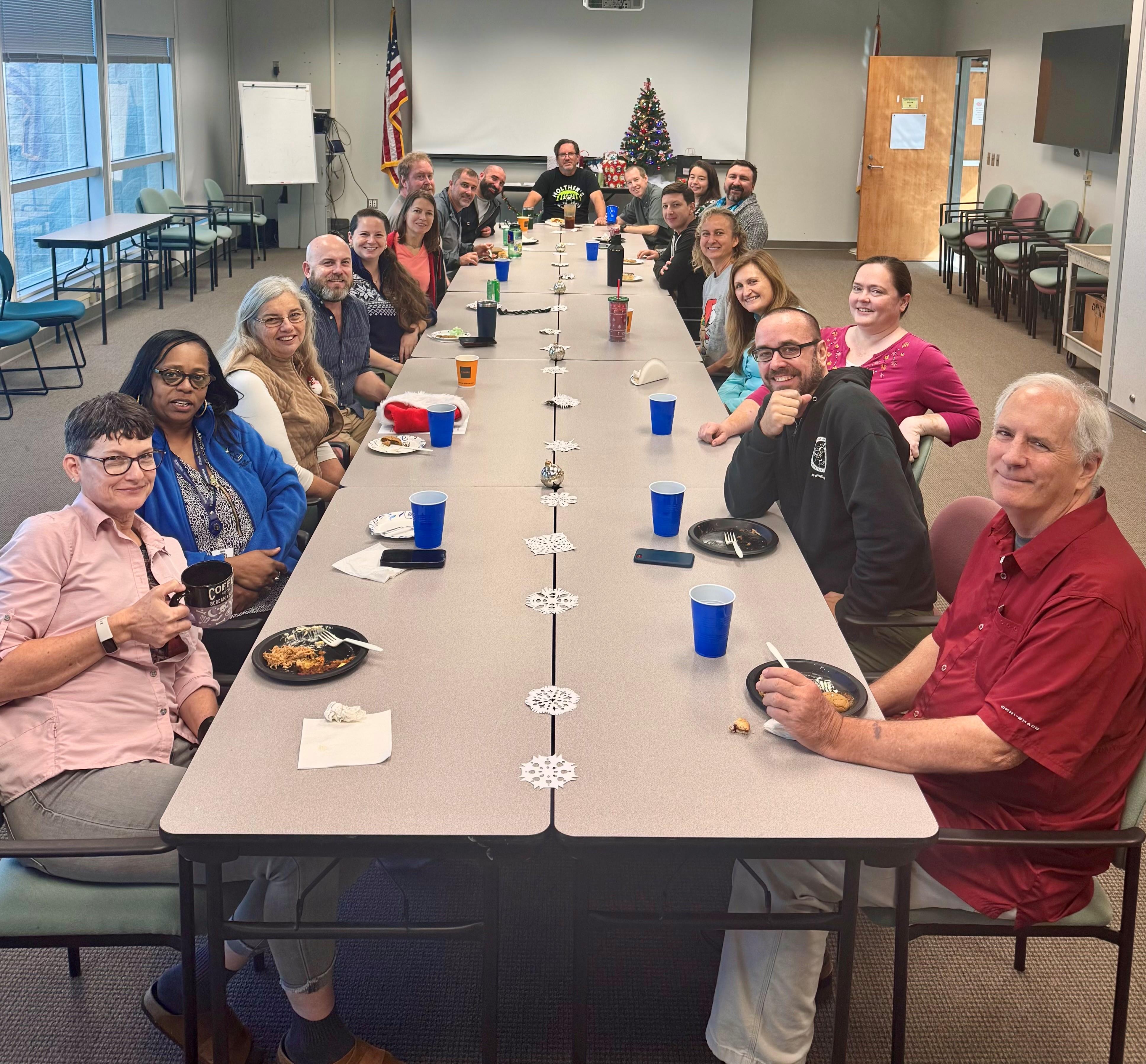 A group of people sitting at a long table