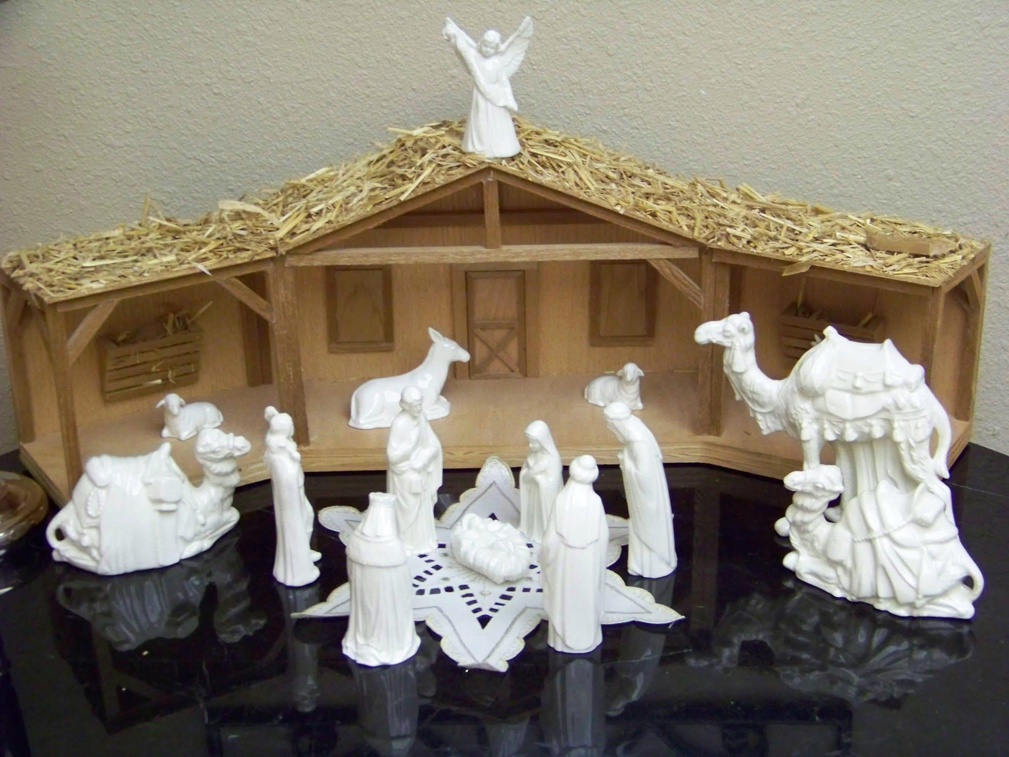A white nativity scene with camels and a manger