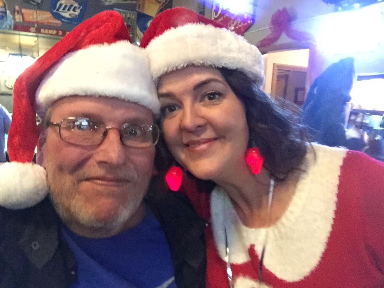 A man and woman wearing santa hats